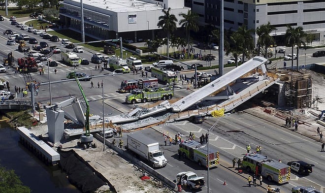 Emergency personnel respond after a brand-new pedestrian bridge collapsed onto a highway at Florida International University in Miami on March 15. The pedestrian bridge collapsed onto the highway crushing multiple vehicles and killing several people. [Pedro Portal/Miami Herald]