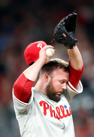 Phillies relief pitcher Tommy Hunter wipes his face between batters in the seventh inning Thursday. [John Bazemore/The Associated Press]