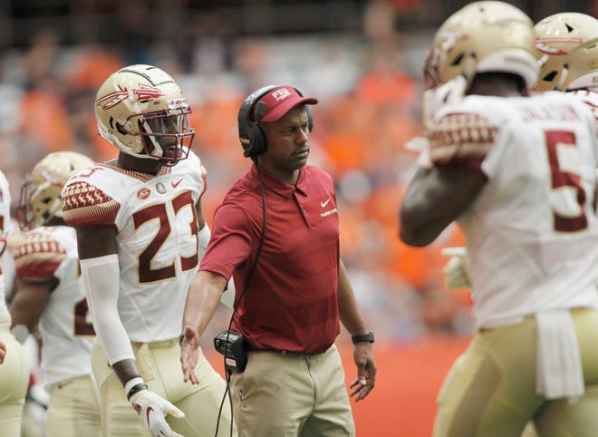 Florida State head coach Willie Taggart greets players coming off the field in the second quarter during a 30-7 loss to Syracuse. [AP Photo/Nick Lisi]