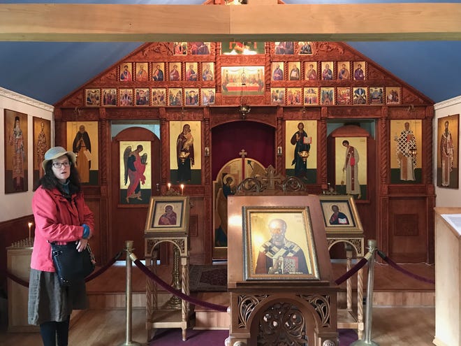 A guide describes the icons inside the Russian Orthodox Church in Elutna, Alaska. [Photo by Rick Holmes]
