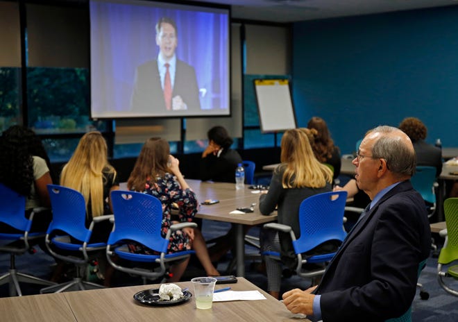 Former Ohio Gov. Bob Taft, far right, joins students for a watch party during a debate between Republican gubernatorial candidate, Ohio Attorney General Mike DeWine and Ohio Democratic gubernatorial candidate Richard Cordray, shown on the screen, at the University of Dayton, Wednesday, Sept. 19, 2018, in Dayton, Ohio. (AP Photo/Gary Landers)