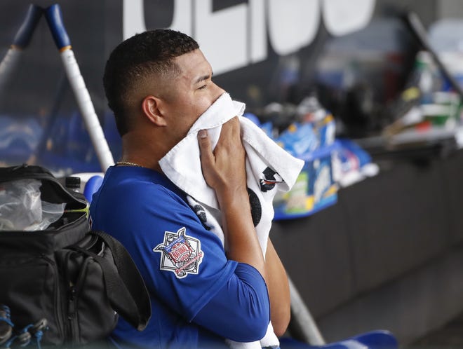 Chicago Cubs starting pitcher Jose Quintana wipes his face as he sits in the dugout after leaving the team's baseball game against the Chicago White Sox during the sixth inning Friday, Sept. 21, 2018, in Chicago. (AP Photo/Kamil Krzaczynski)