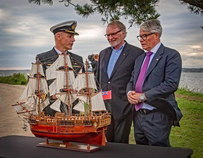 From right, the Honorable Alistair Walton, Australian consul general, and Peter Dexter, chairman of the board of the Australian National Maritime Museum, discuss a model of the Endeavour with Michael Noonant, aide to vice admiral of the Royal Australian Navy, on Friday on Goat Island in Newport. [PATRICIA CAHILL TAFT]