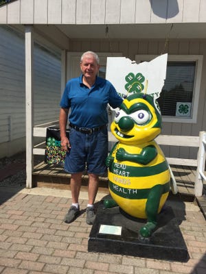 SUBMITTED PHOTO John Lyons of Dover visited every one of the 88 Ohio County Fairs over a two-year period. Here he has his photo taken with bee at the Medina County Fair.