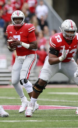 Ohio State quarterback Dwayne Haskins looks for a receiver in the first quarter against Tulane. He usually found one, finishing 21-of-24 for 304 yards and five touchdowns in playing only the first half. [Brooke LaValley/Dispatch]