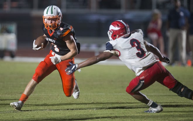 Mosley's Alex Noble evades the tackle of Fort Walton Beach's Daquis Upshaw during Friday's game at Tommy Oliver Stadium. [JOSHUA BOUCHER/THE NEWS HERALD]