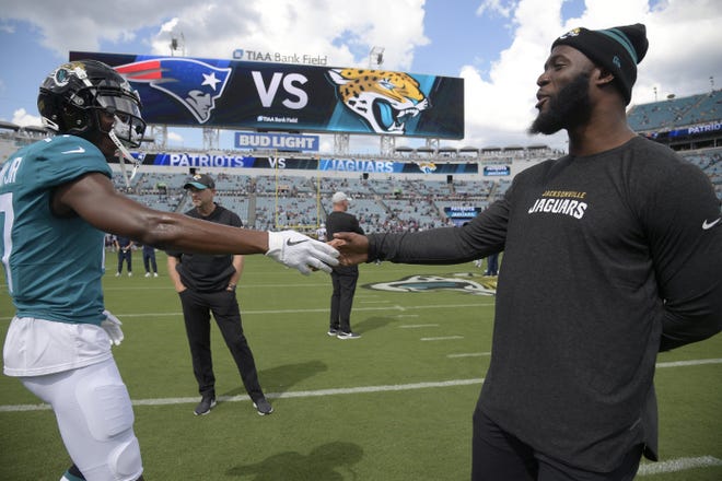 Jaguars receiver D.J. Chark (17) and running back Leonard Fournette shake hands during warm-ups before a game against the New England Patriots on Sept. 16. [Associated Press photo]