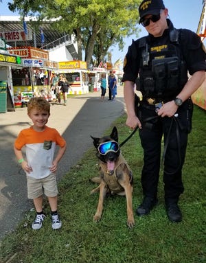 Jacoby Cannon, 4, is with Deputy Chris Edward and K-9 Chucky at the Tuscarawas County Fair Wednesday. Jessica Cannon shared the photo.