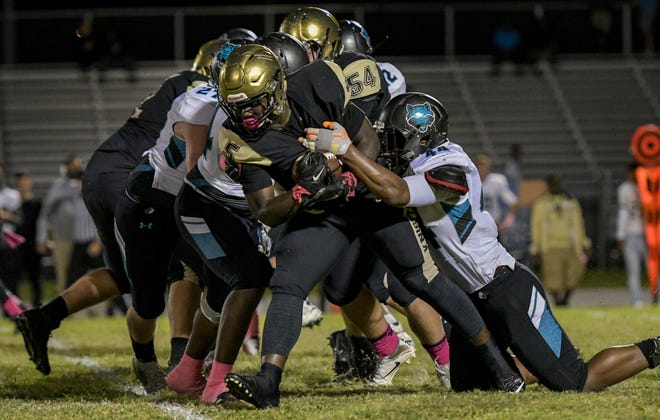 East Ridge's Bryan Lumsden (5) powers past West Port's Tavares Marks (44) on Oct. 14, 2016, in Clermont. [DAILY COMMERCIAL FILE]