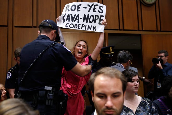 A woman stands and voices her opposition to Supreme Court nominee Brett Kavanaugh, during a Senate Judiciary Committee confirmation hearing on his nomination for Supreme Court, on Capitol Hill, Tuesday, Sept. 4, 2018, in Washington. (AP Photo/Jacquelyn Martin)