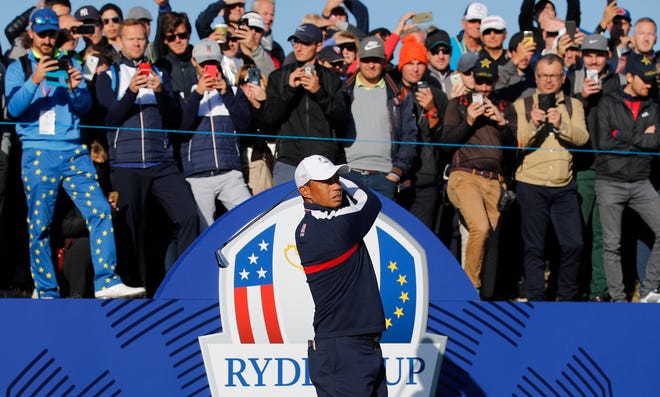 Spectators watch above as Tiger Woods plays from the first tee during practice Tuesday at Le Golf National in Guyancourt, outside Paris. The 42nd Ryder Cup will be held from Friday to Sunday at Le Golf National. [Francois Mori/The Associated Press]