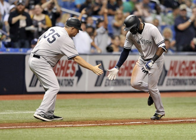 New York third base coach Phil Nevin (35) congratulates Adeiny Hechavarria after his solo home run off Tampa Bay Rays starter Jake Faria during the third inning of Tuesday's game. They would go on to score six more in the inning. [THE ASSOCIATED PRESS]