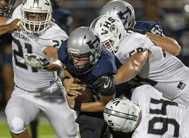 Hendrickson quarterback Blaine Barker (12) is tackled by Vandegrift defensive linemen Joseph Hauck (58) and Matthew Graham (94) during a District 13-6A high school football game at The Pfleld in Pflugerville, Friday, Sept. 21, 2018. (Stephen Spillman / for American-Statesman)
