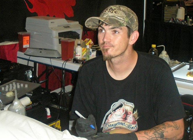 Todd Kimberlin, pictured here tattooing a customer during Leesburg Bikefest in 2012, was a talented artist and devoted father, friends say. [Facebook]