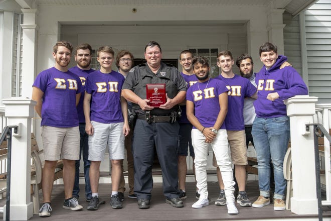 WPI Officer Robert Vandal with Thomas White (behind him on the right) and other members of the WPI chapter of Sigma Pi. [Submitted photo/Matthew Burgos]