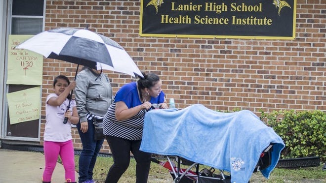 Families make their way in the rain outside Lanier High School. Lanier is among the five schools with ties to the Confederacy that will be renamed. RICARDO B. BRAZZIELL/AMERICAN-STATESMAN