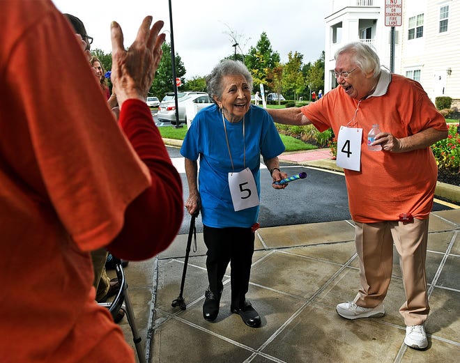 Selma Carmy congratulates Ronnie Monokian as she crosses the finish line in the Brightview Senior Living relay walk event in Evesham on Wednesday. [NANCY ROKOS / STAFF PHOTOJOURNALIST]