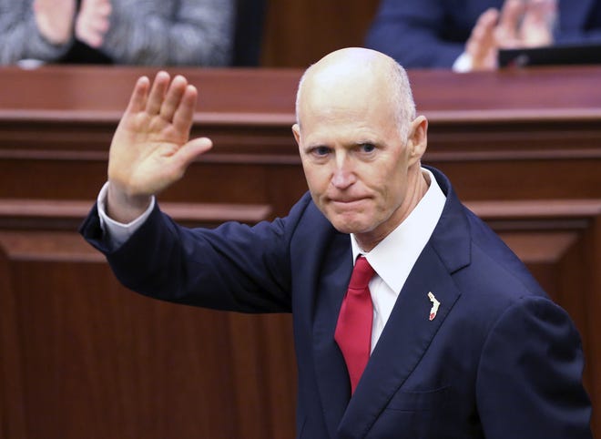 Gov. Rick Scott waves as he is introduced to the Senate on the first day of legislative session on Jan. 9 in Tallahassee. Scott wants to select three new Florida Supreme Court justices before he leaves office. [AP Photo/Steve Cannon]