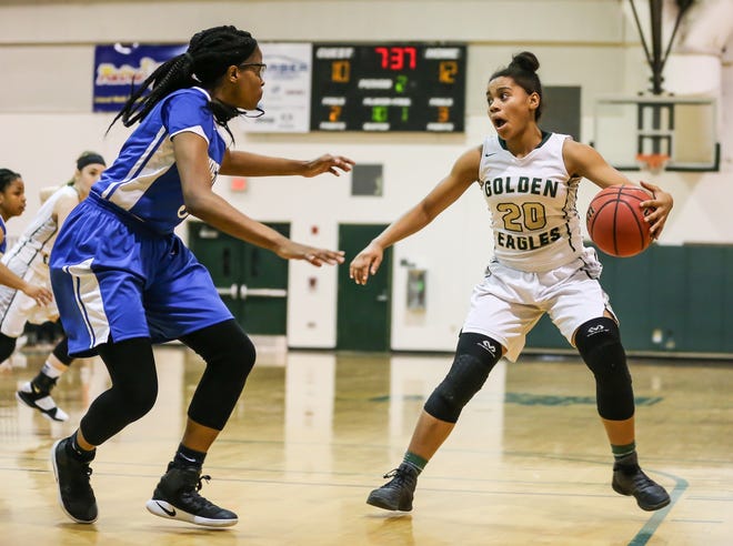 Fleming Island's Tia Robinson (right) prepares to challenge First Coast defender Kaytlynn Williams in a Region 1-8A girls basketball playoff. The FHSAA has revised a plan that would have overhauled girls basketball and six other sports. [Gary Lloyd McCullough/For the Times-Union]