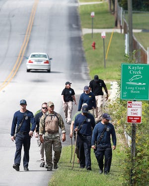 A search team walks down Tulip Drive in Gastonia Wednesday morning. Local law enforcent officers, fire and rescue personnel, and the FBI continued to look for clues to the whereabouts of 6-year-old Maddox Ritch who disappeared from Rankin Lake Park Saurday. [JOHN CLARK/THE GASTON GAZETTE]