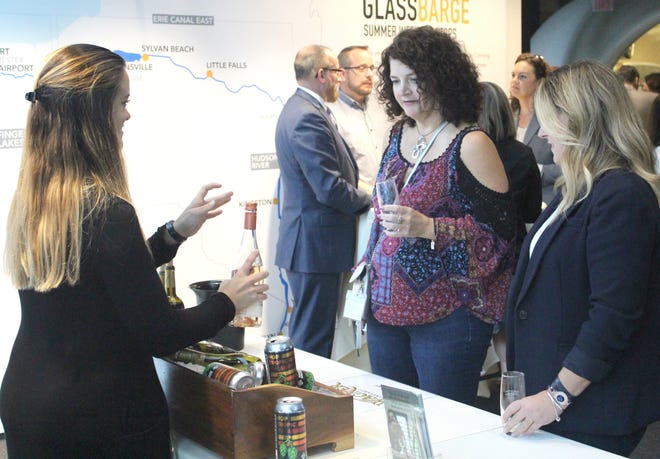 A Wagner Vineyards employee describes a bottle of its Rosé to guests at the Hops & Grapes fundraiser Thursday evening at CMoG. [JANA AIKEN/THE LEADER]