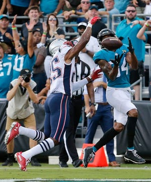Jacksonville Jaguars wide receiver Keelan Cole, right, catches a pass for a 24-yard touchdown in front of New England Patriots defensive back Eric Rowe during the first half of an NFL football game, Sunday, Sept. 16, 2018, in Jacksonville, Fla.