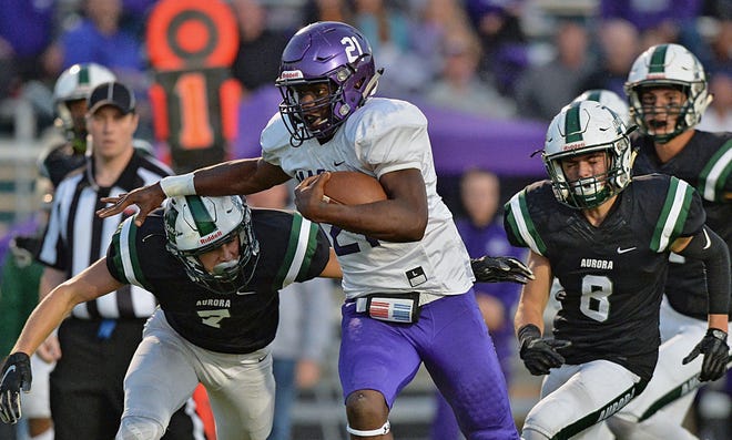 Barberton running back Kyrie Young breaks away from Aurora's Graham Aldredge (left) and James Austin (right) on his way to a touchdown during the first quarter Friday at Aurora High School. [Jeff Lange/ABJ/Ohio.com correspondent]