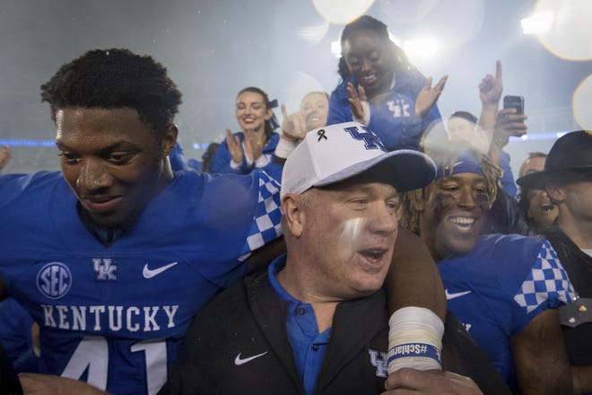 Kentucky coach Mark Stoops celebrates with players and fans on the field after the team's 28-7 win over Mississippi State during an NCAA college football game in Lexington, Ky., Saturday, Sept. 22, 2018. [Bryan Woolston/The Associated Press]