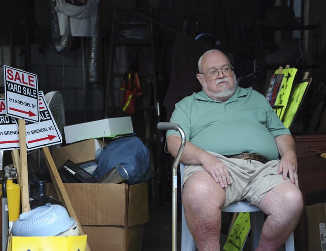 Willie Davis, a U.S. Navy veteran who is dying from cancer, sits in his garage on Wednesday among many of his belongings, which he's trying to sell to help pay for his own funeral in Johnstown, Pa. [JOHN RUCOSKY/TRIBUNE-DEMOCRAT]