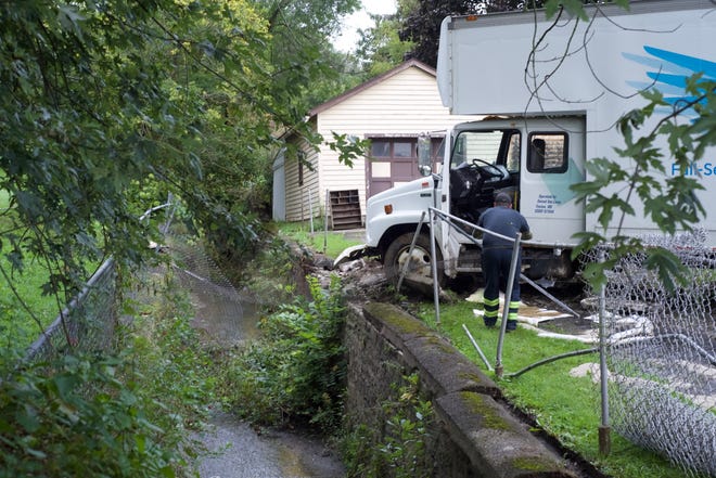 A moving van rests at 435 Rose Ave. in Hornell after rolling uncontrolled down Gypsy Hill and hopping a creek on Thursday morning, resulting in damage to two fences and a home. [LYNN WHITE PHOTOS]