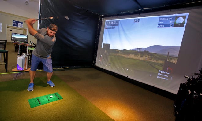 Co-owner Brad Atkins takes a swing in a golf simulator at Shankville of Shelby on Thursday. [Brittany Randolph/The Star]