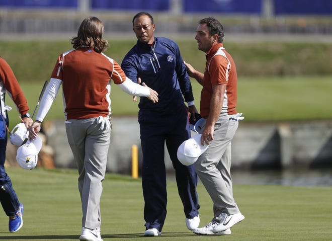 Europe's Tommy Fleetwood, left, and Francesco Molinari greet Tiger Woods of the United States after a fourball match Saturday on the second day of the 42nd Ryder Cup at Le Golf National in Saint-Quentin-en-Yvelines, outside Paris, France. Fleetwood and Molinari beat Woods and Patrick Reed 4 and 3. [ALASTAIR GRANT/THE ASSOCIATED PRESS]