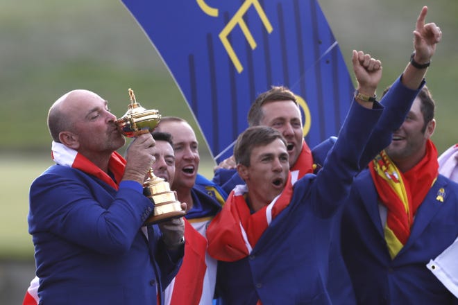 Europe team captain Thomas Bjorn kisses the cup as he celebrates with his players after the European team won the 2018 Ryder Cup golf tournament at Le Golf National in Saint Quentin-en-Yvelines, outside Paris, France, Sunday, Sept. 30, 2018. (AP Photo/Alastair Grant)