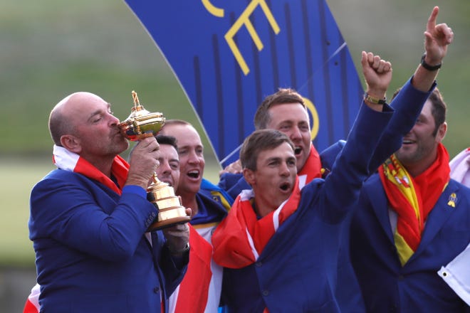 Europe team captain Thomas Bjorn kisses the cup as he celebrates with his players after the European team won the 2018 Ryder Cup golf tournament at Le Golf National in Saint Quentin-en-Yvelines, outside Paris, France, Sunday, Sept. 30, 2018. (AP Photo/Alastair Grant)