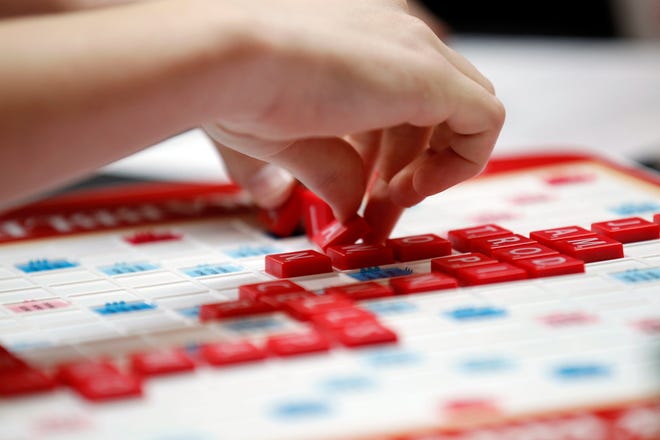 This May 16, 2015 photo released by Hasbro shows a contestant competing in the first round of the 2015 North American School Scrabble Championship at Hasbro headquarters in Pawtucket, R.I. Merriam-Webster released the sixth edition of “The Official Scrabble Players Dictionary” early Monday with more than 300 additions. (Stew Milne/Hasbro via AP)
