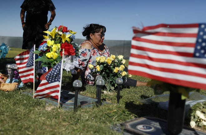 Angelica Cervantes sits at her son Erick Silva's grave Saturday in Las Vegas. Silva was one of 58 people killed Oct. 1, 2017, in the deadliest mass shooting in modern U.S. history. [JOHN LOCHER/THE ASSOCIATED PRESS]