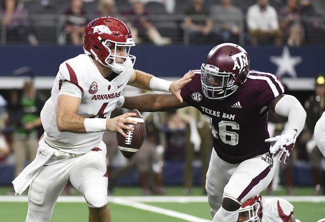 Arkansas quarterback Ty Storey (4) tries to avoid the pressure from Texas A&M defensive lineman Landis Durham (46) during the first quarter Saturday, Sept. 29, 2018, in Arlington, Texas. Storey was sacked on the play. [AP Photo/Jeffrey McWhorter]