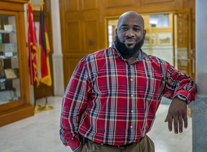 DAVID ZALAZNIK/JOURNAL STAR City of Peoria Diversity Officer Farris Muhammad stands in the hallway of Peoria City Hall.