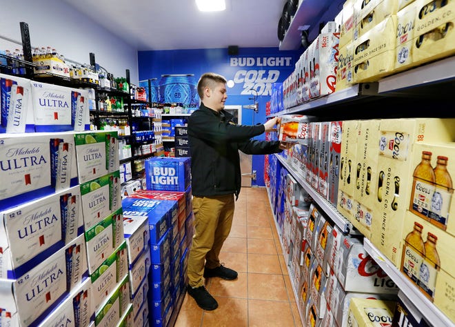 OnCue clerk Braxtun Brown arranges products inside the store's Beer Cave Monday, Oct. 1, 2018. [Jim Beckel/The Oklahoman]