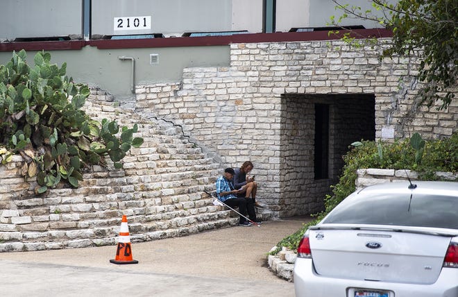 Two men on Sunday sit outside of South Austin Market Place, a halfway house located at 2101 E. Ben White Blvd. in Southeast Austin, where Norman McCarty was fatally shot late Saturday night in the parking lot. [NICK WAGNER/AMERICAN-STATESMAN]