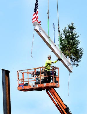 A construction worker raises the final steel beam before securing it in place Thursday for the new St Luke's Hospital being built in Milford. [ART GENTILE / STAFF PHOTOJOURNALIST]