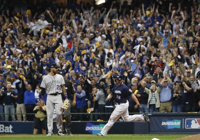 Milwaukee Brewers' Mike Moustakas hits a walk off RBI single during the 10th inning of Game 1 of the National League Divisional Series against the Colorado Rockies on Thursday in Milwaukee. [AP Photo/Jeff Roberson]