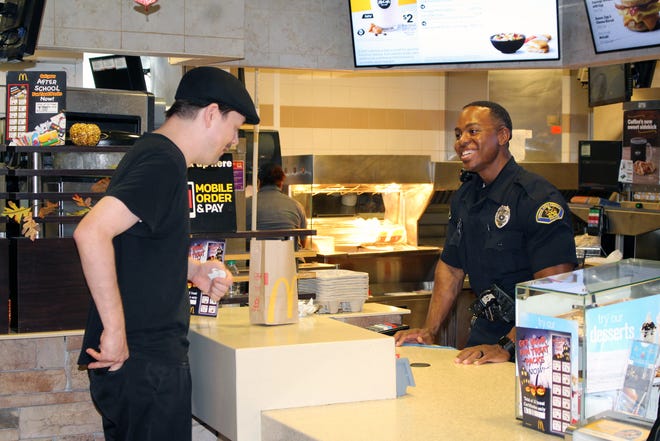 Stroud Area Regional Police Officer Jerome Taylor seves Johnny Rydell at Stroudsburg's Main St. McDonald's during Coffee with a Cop day, an event that allows law enforcement officers to peacefully engage with their local communities. [BRIAN MYSZKOWSKI/POCONO RECORD]