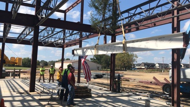 Crews with Holmes Erection raise the final steel beam on the Arkansas College of Health Sciences in Fort Smith on Wednesday. The Arkansas Colleges of Health Education broke ground on the $25 million project at Chaffee Crossing, next to the Arkansas College of Osteopathic Medicine, in late May. Beshears Construction expects to complete the building in October 2019. [JOHN LOVETT/TIMES RECORD]