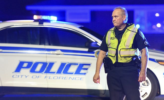 A police officer directs traffic on Hoffmeyer Road near the Vintage Place neighborhood Wednesday , in Florence, S.C., where seven law enforcment officers were shot, one fatally. [AP Photo/Sean Rayford]
