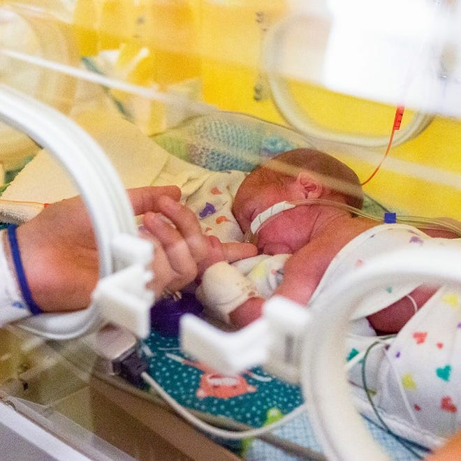 John Shea, born prematurely, rests in an isolette as he clutches his mother's finger in the neonatal intensive care unit at UMass Memorial Hospital on Belmont Street in Worcester.
