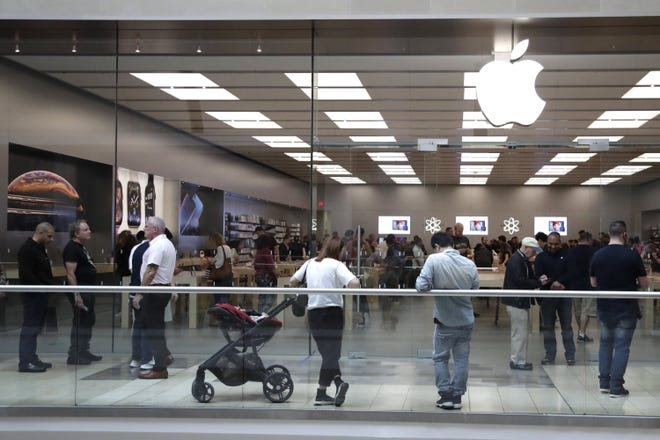 Customers wait in line outside of the Apple Store at the Garden State Plaza on the day the new iPhone XS was released, Friday, Sept. 21, 2018, in Paramus, N.J. (AP Photo/Julio Cortez)