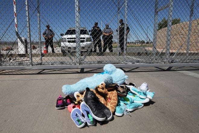A pile of shoes and a teddy bear are seen in June in front of a fence at the Tornillo-Guadalupe Port of Entry, where the government recently moved hundreds more migrant children to live in a tent city. [Photo by Joe Raedle/Getty Images]