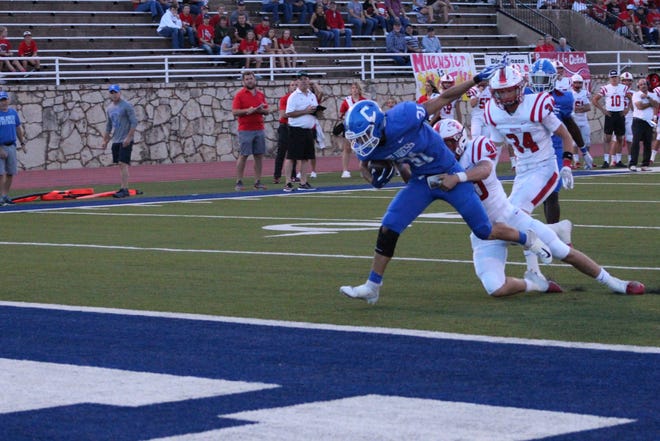 Childress running back Miguel Salinas carries a Muenster defender in for a touchdown in the first quarter at Fair Park Stadium. [Ginger Wilson/ For the Amarillo Globe-News]