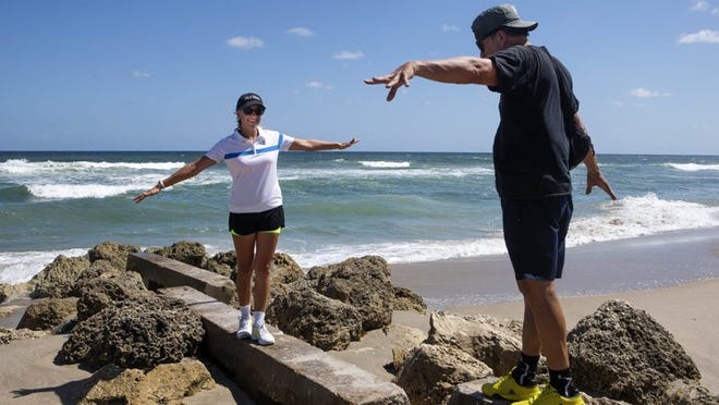 George and Olivia Tullot, of Palm Beach balance on concrete blocks while taking a walk along Palm Beach on Friday, October 5, 2018. George said that while the red tide has bothered him before, today he wasn’t feeling it. (James Wooldridge / The Palm Beach Post)